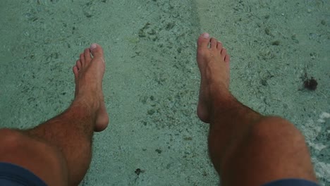 Männerfüße-über-Wasser-In-Französisch-Polynesien.-Sonniger-Tag